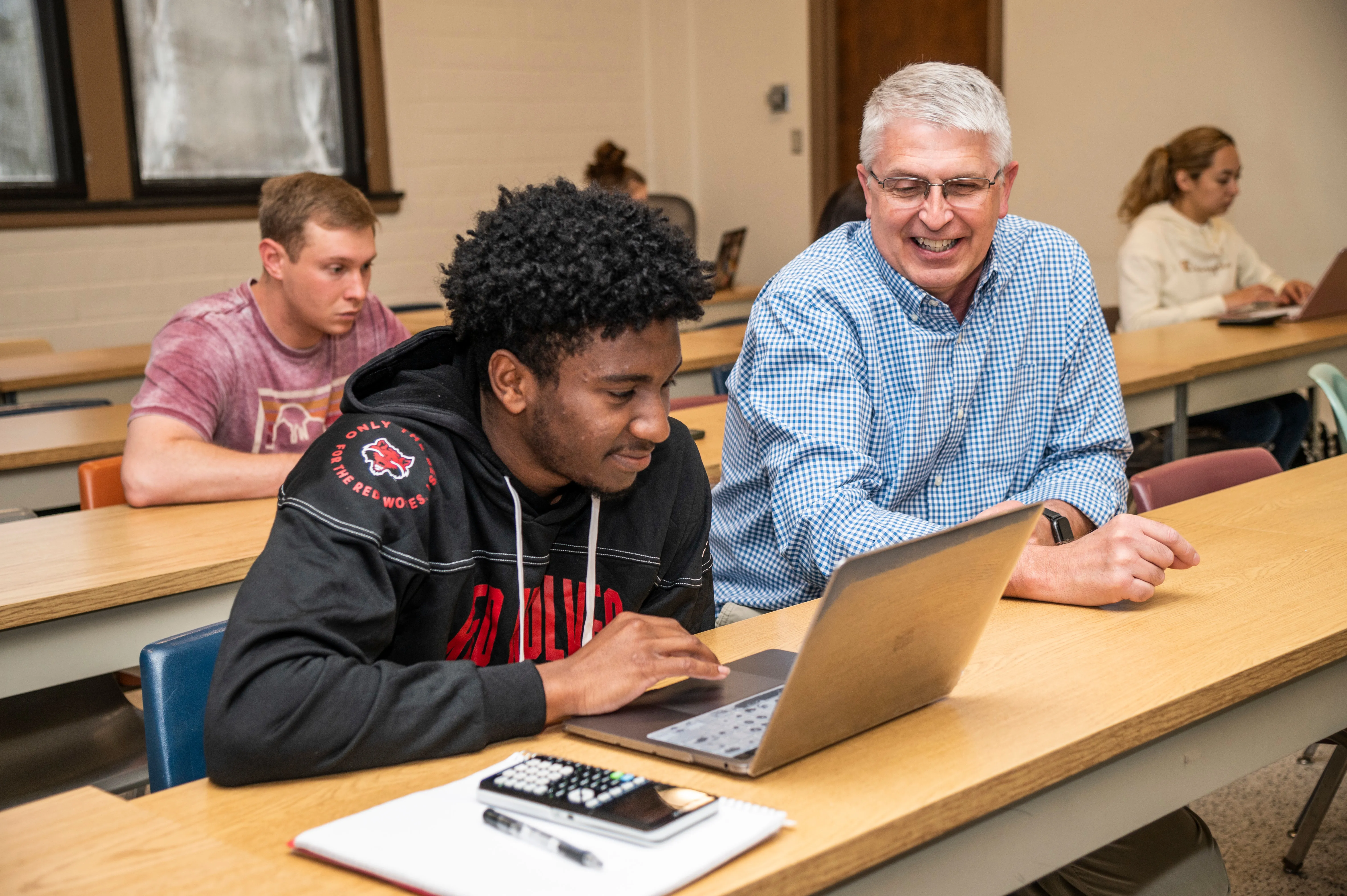 A-State student working with teacher in accounting classroom.