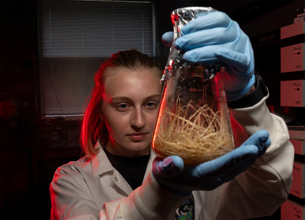 student holding up glass beaker