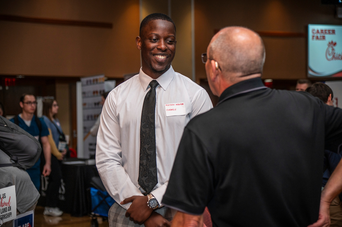An A-State student speaks with a local businessman at a university career fair.