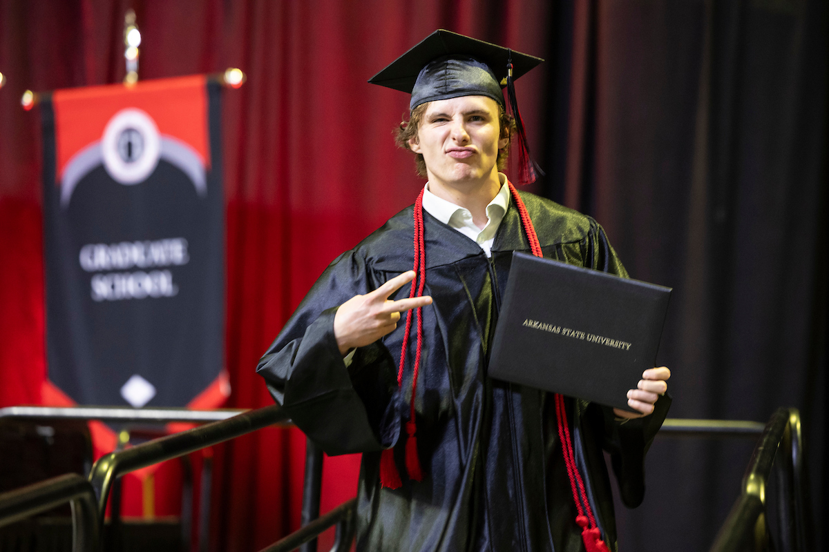 An A-State student smirks as he walks across the stage at a recent commencement ceremony.