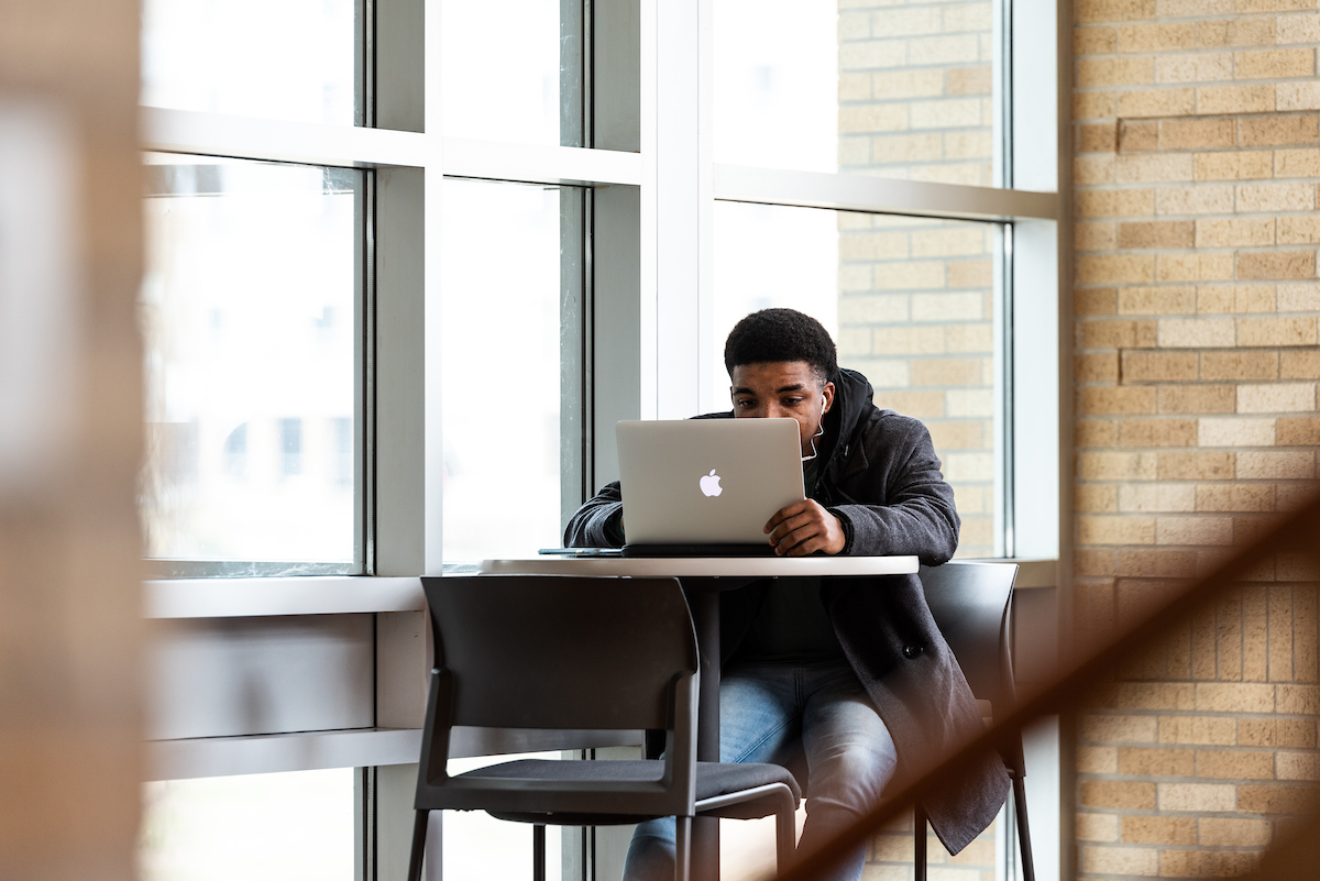 student studying on laptop by window