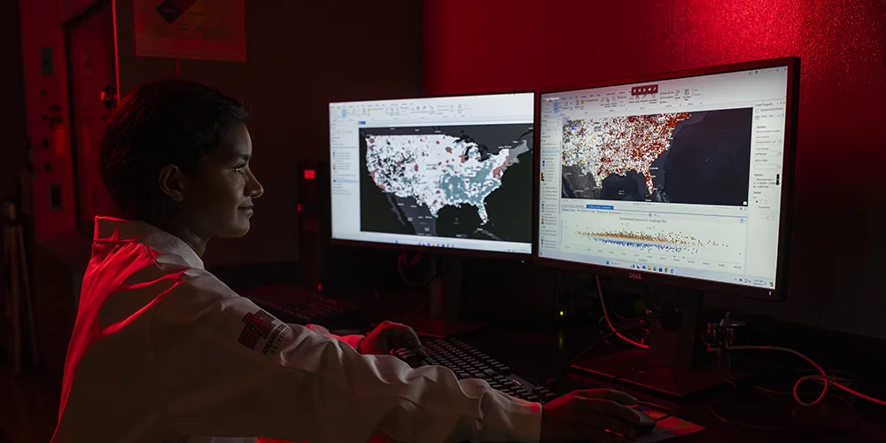 A student studying results on a computer.