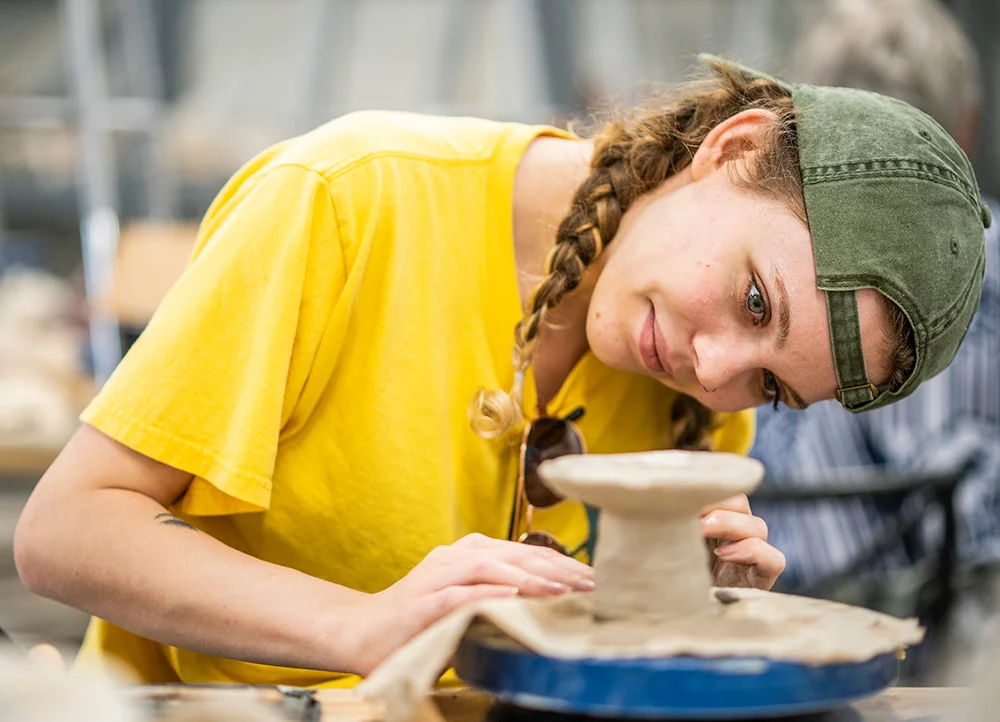 A student working on a ceramics wheel
