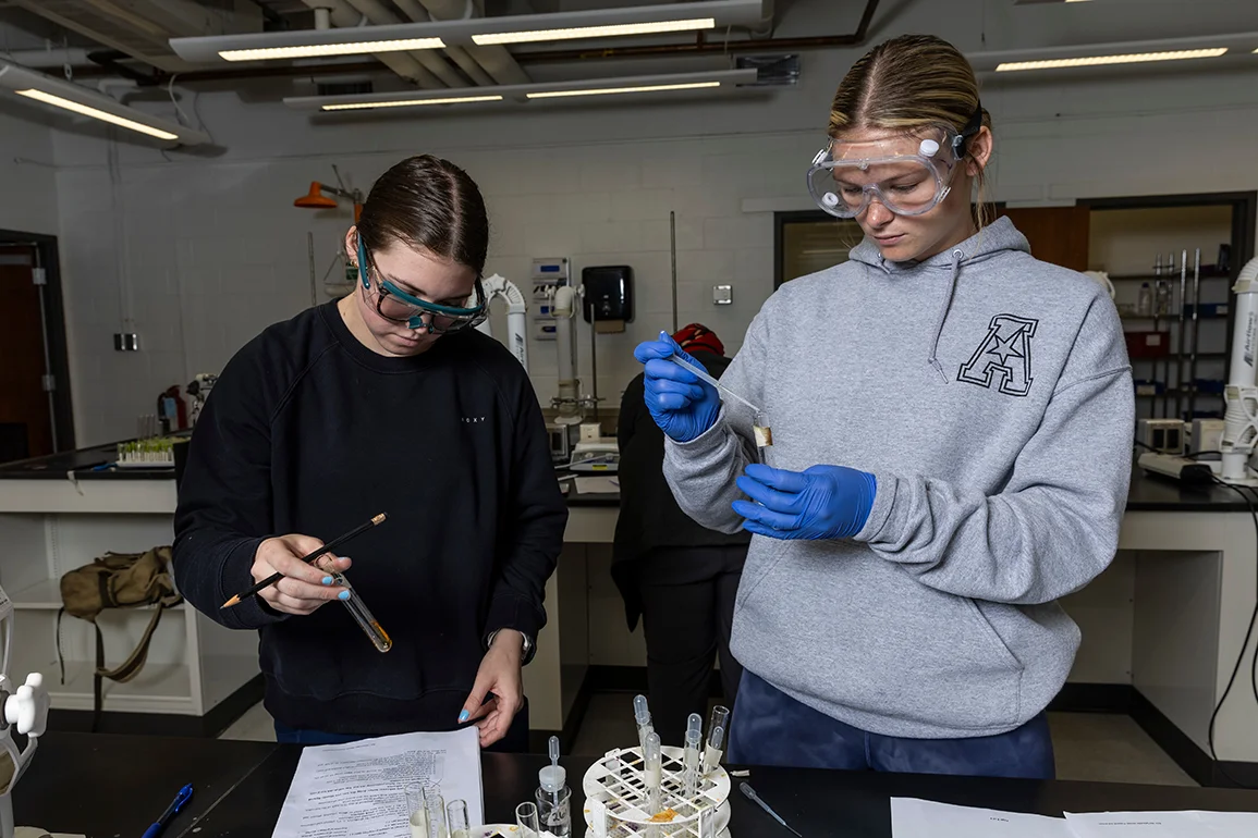 Two students examining vials.
