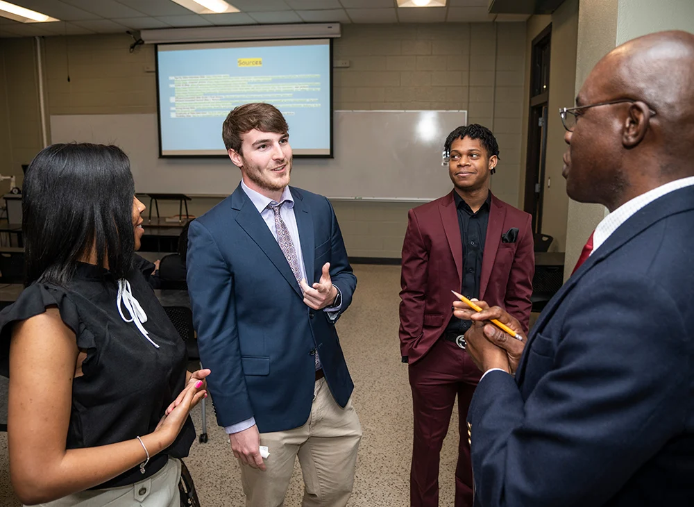 A professor having a discussion with a group of students.