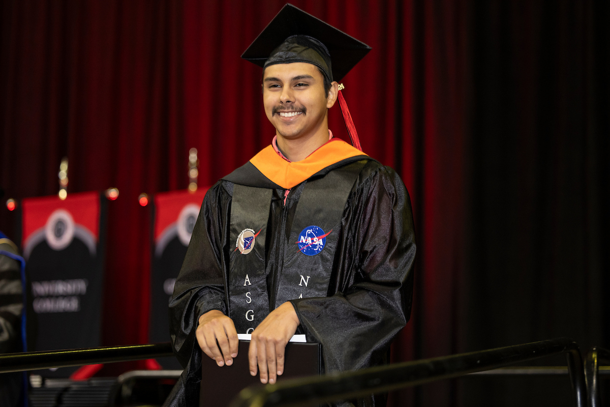 A graduate smiles at the crowd during a recent commencement ceremony.