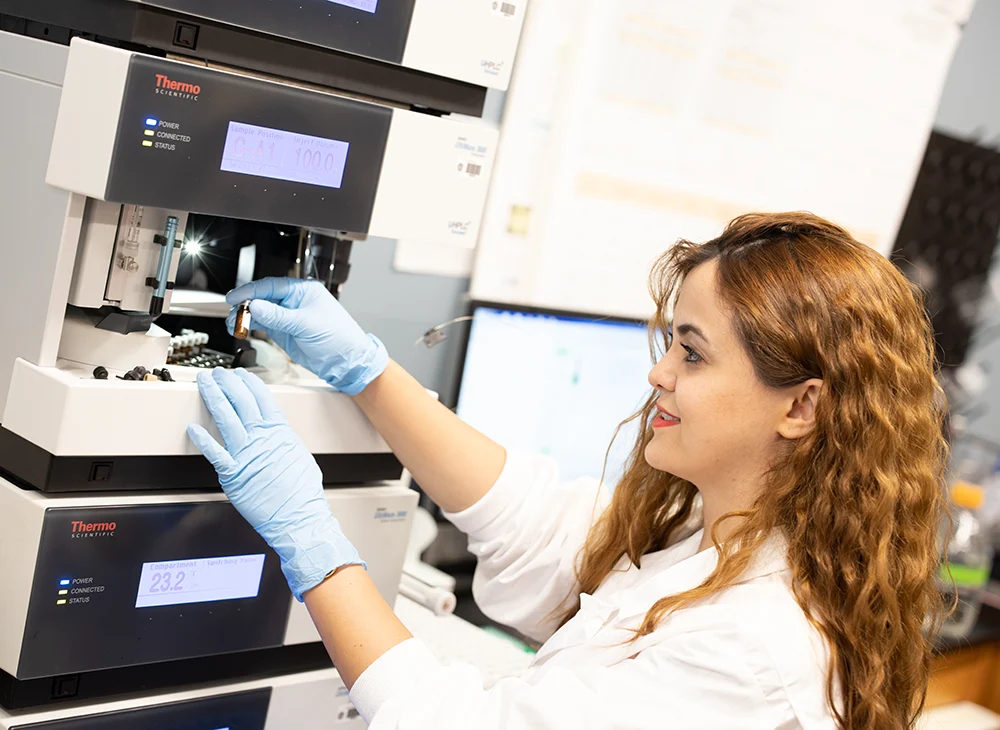 A student using a machine in a lab.