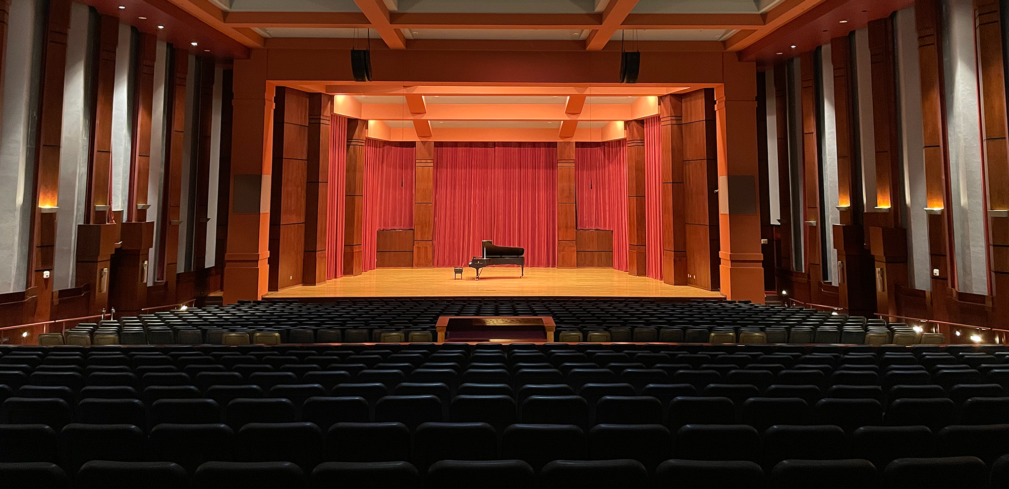A stage in Riceland Hall with a piano in the center.