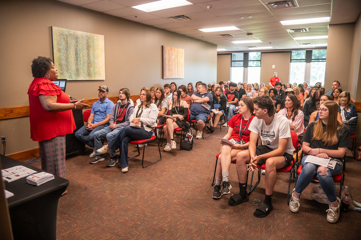 Presenter from seminar presenting to audience in A-State room.