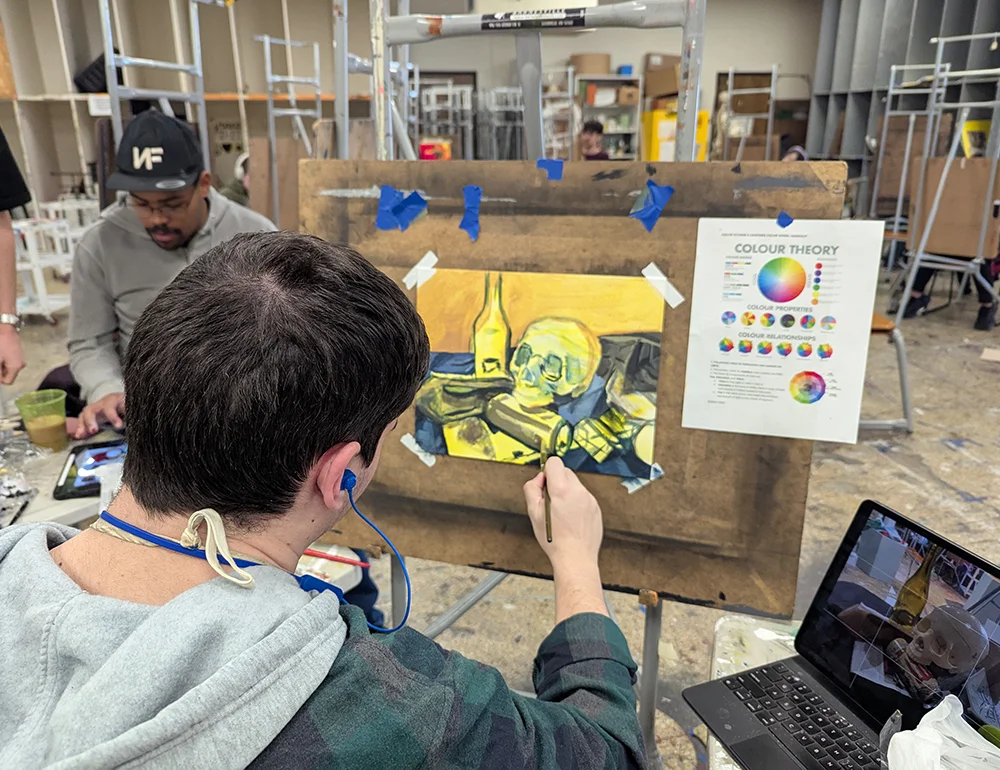 Students painting a still life in class.