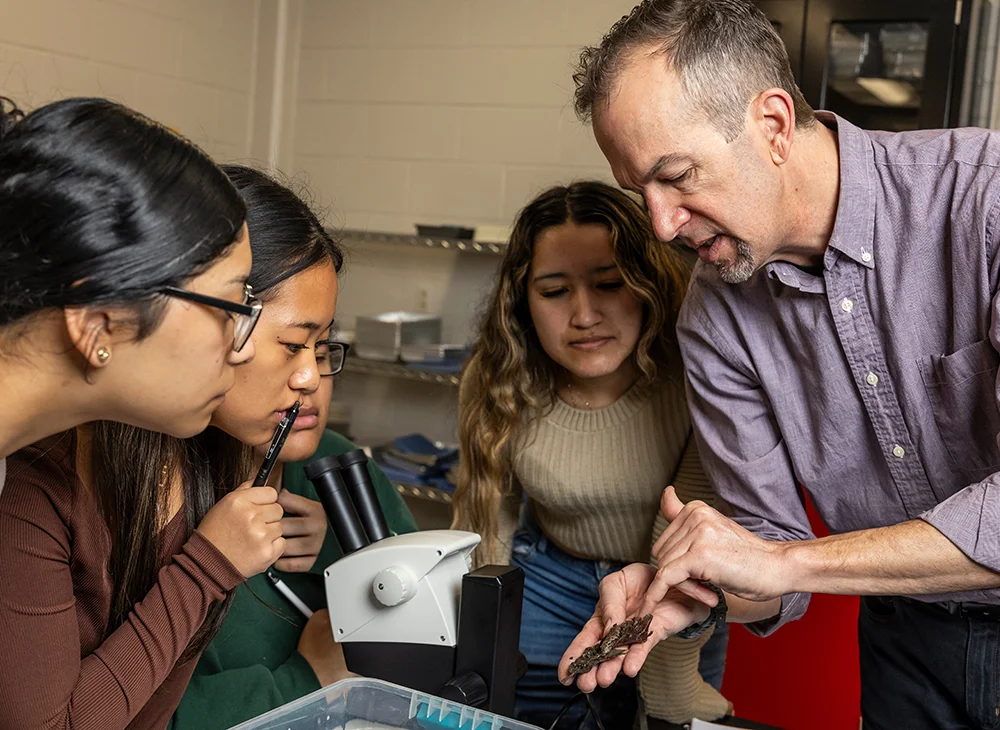 Professor showing students slugs during a lab.
