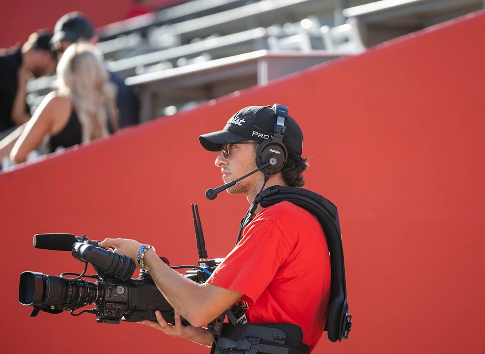 Student filming a sports game.