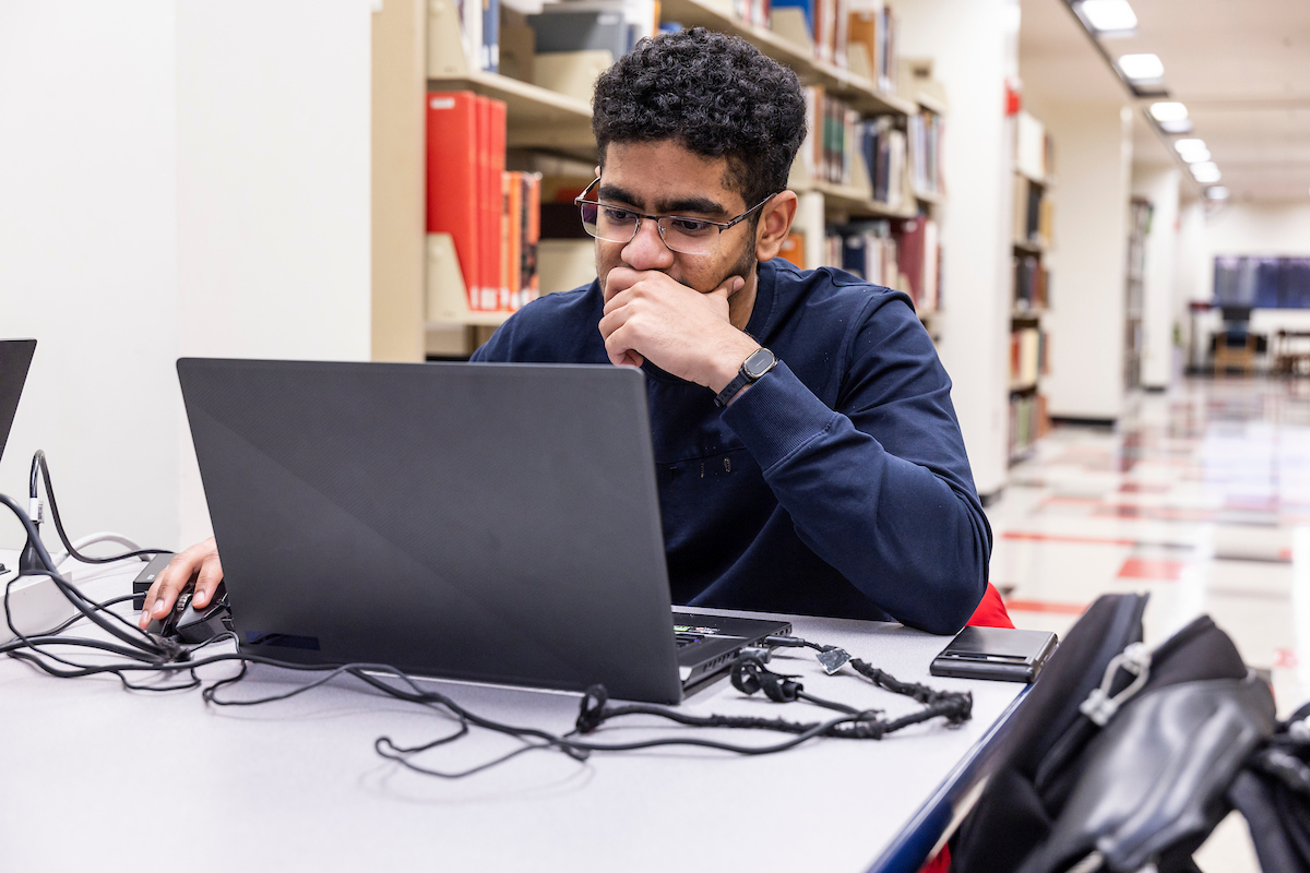 A student works on a laptop during a study session at the Dean B. Ellis Library