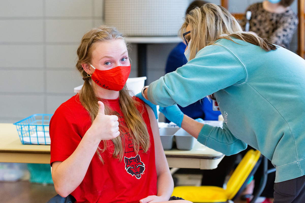 A student giving a thumbs up as they receive their yearly vaccine.