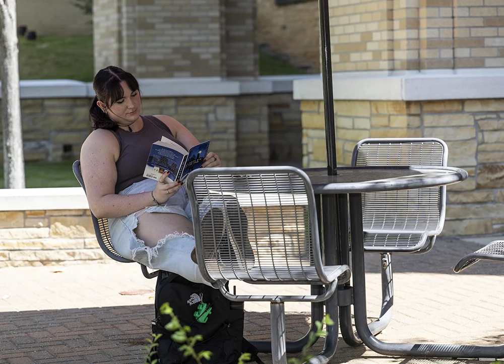 Student reading a book outside.
