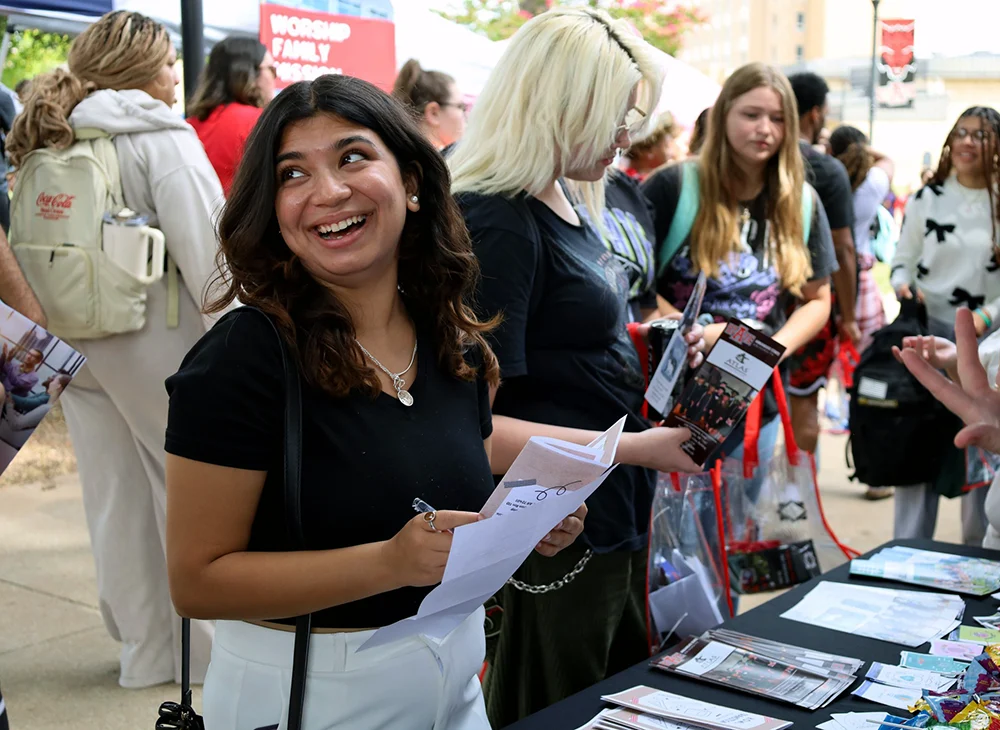 Student smiling at an organization fair.