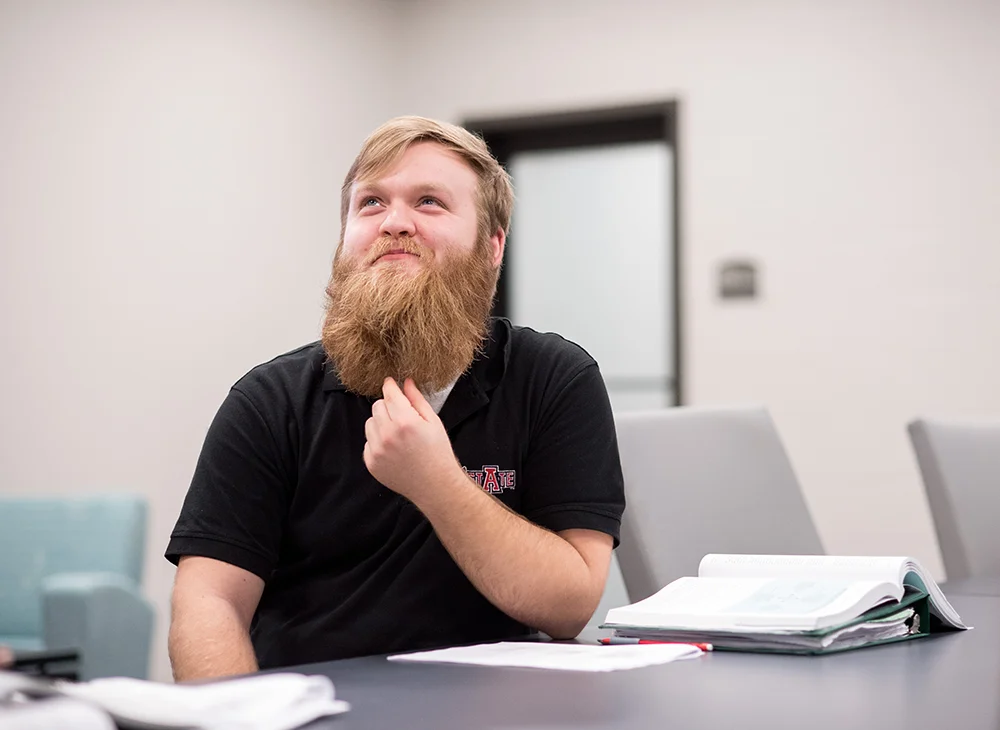 Student stroking his beard in thought