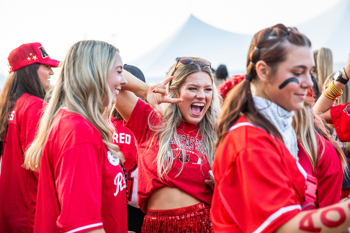 A student in Red Wolf gear gives a Wolves Up.