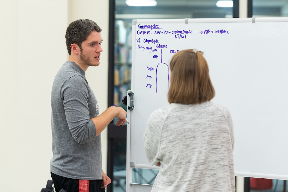 A-State students reviewing notes together at a whiteboard.