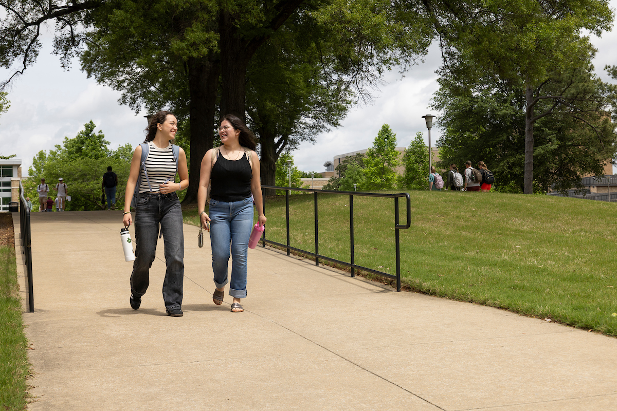 Two students walking on campus together.