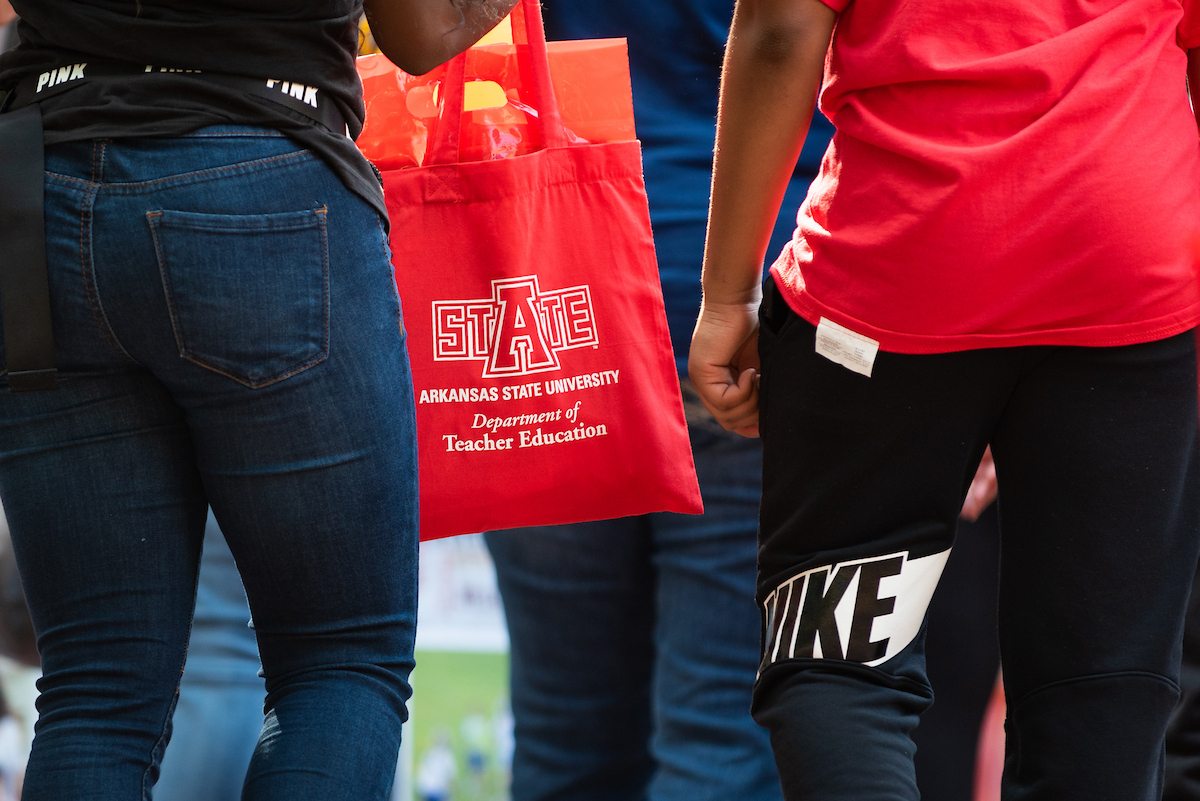 Close-up of a red A-State tote bag carried during a campus event.
