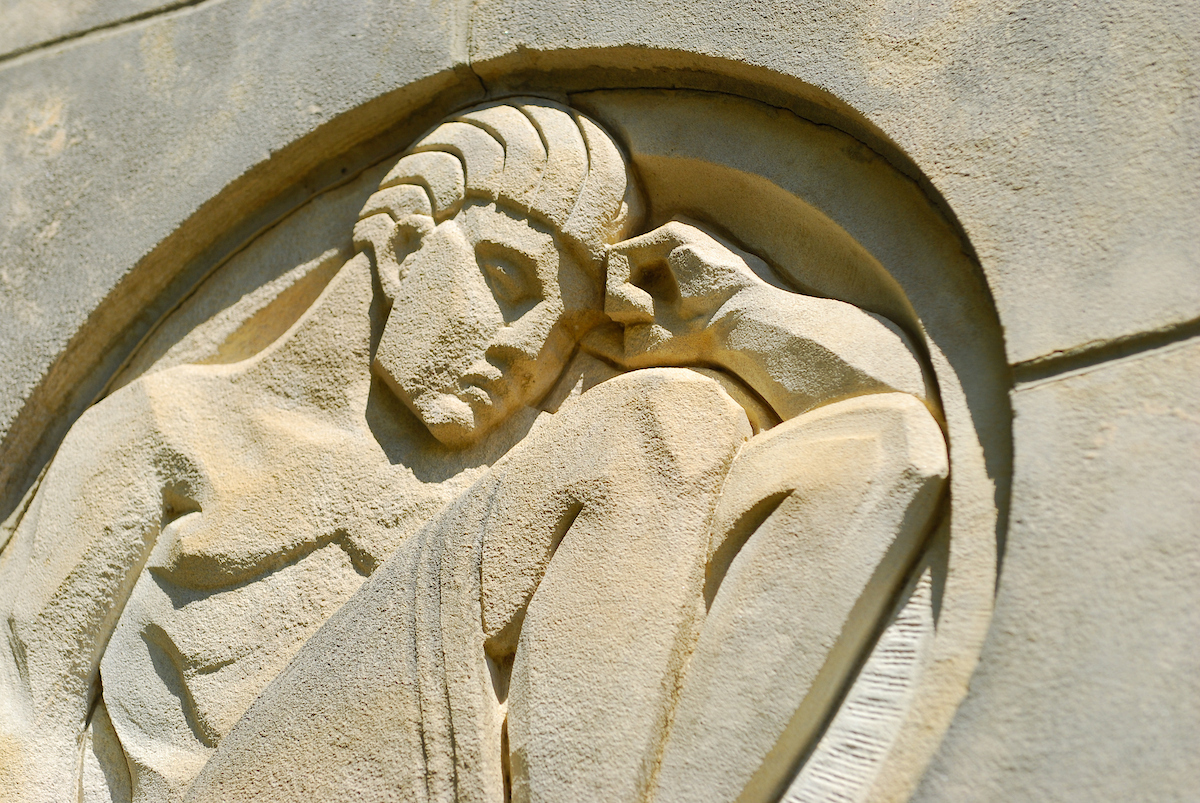  “The Scholar” is etched in stone outside Wilson Hall.