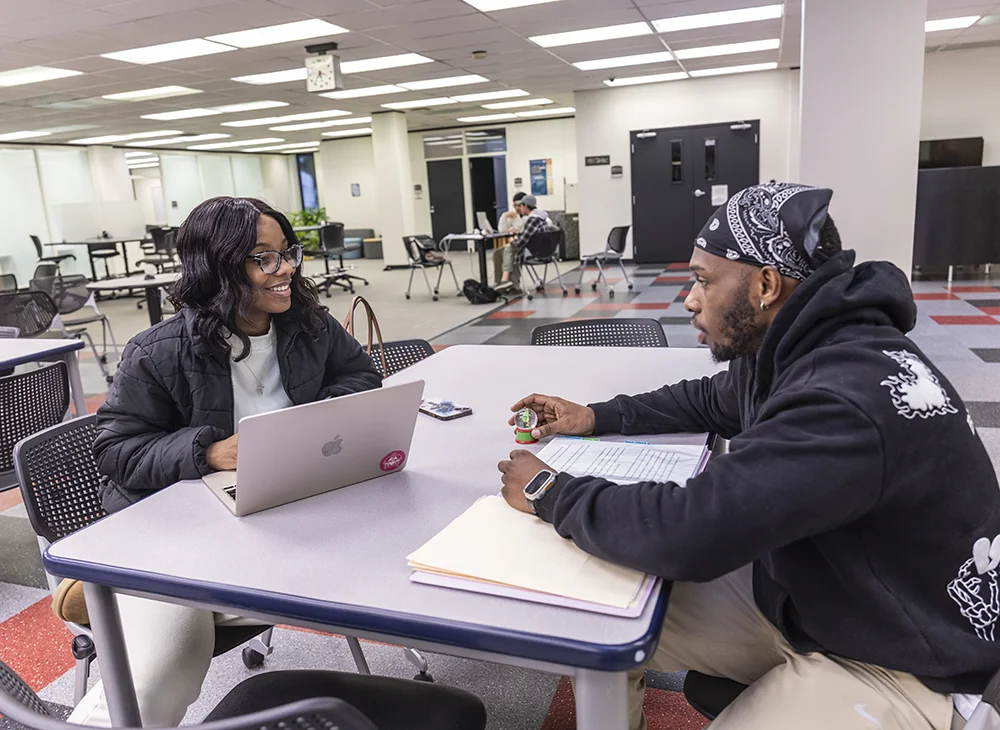 A student and tutor talking in the Writing Center.