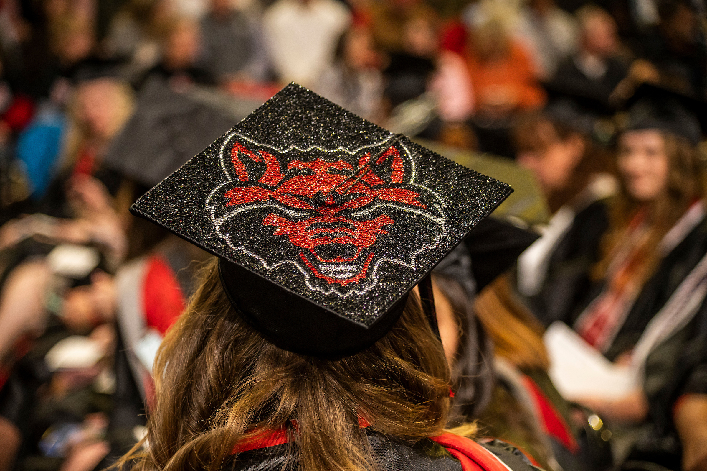 A graduation cap decorated with the A-State Red Wolves logo during commencement ceremony.