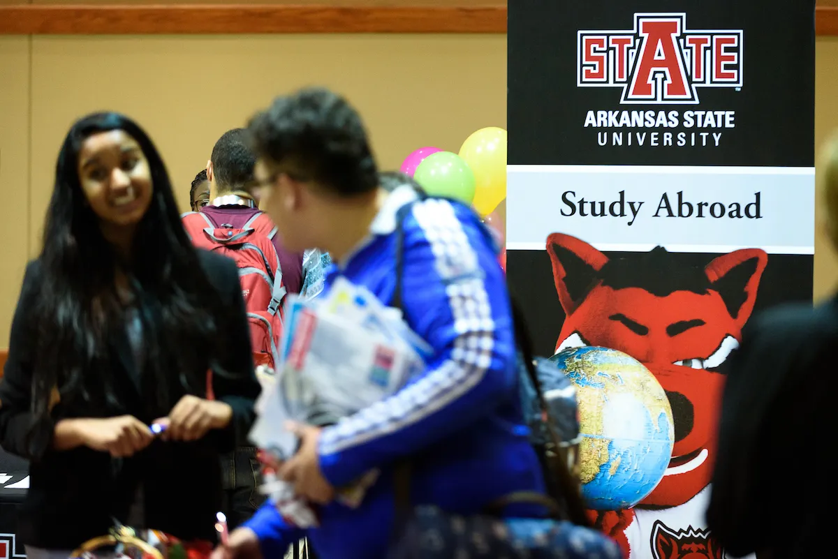 Students visit a study abroad booth during a campus fair.