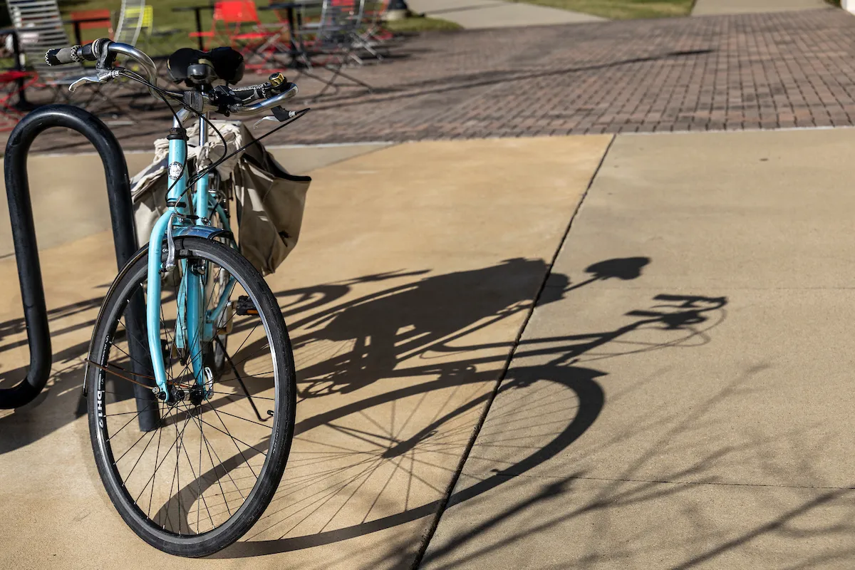 A bike rests against a bike rack on campus.