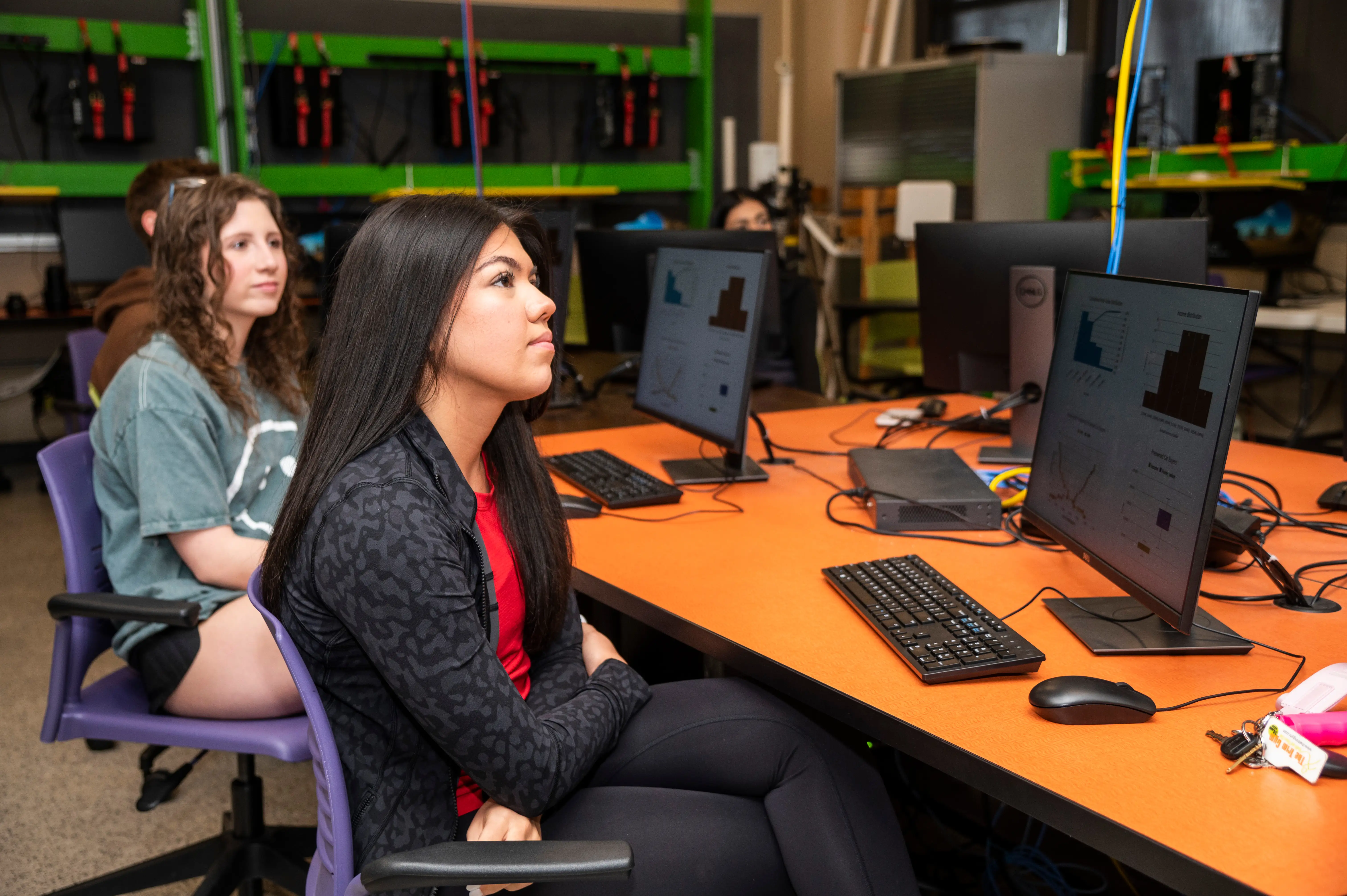 a-state students in data science and ai class watching professor while sitting at tables working on data aggregation.