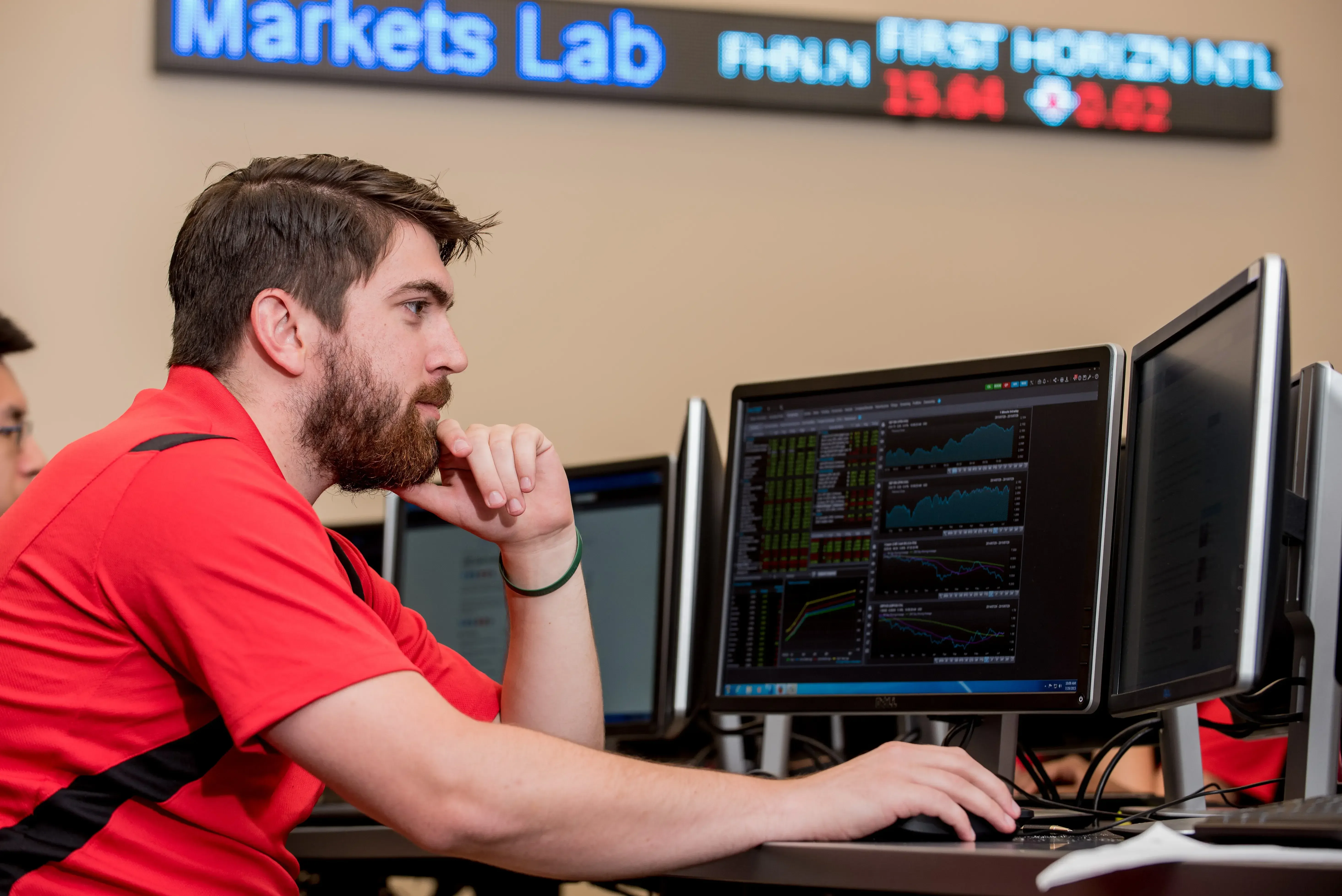 Student studying economics and stock exchange in the Dawson Finance Center on campus.