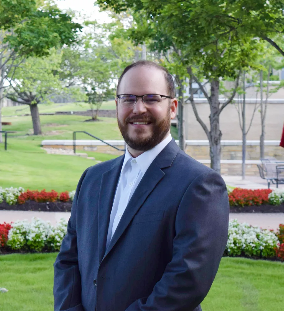 Justin Carothers headshot outside of the A-State campus.