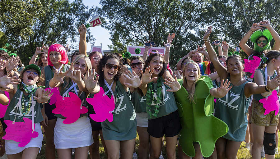 Sorority women waving and cheering at Sorority Bid Day celebration.