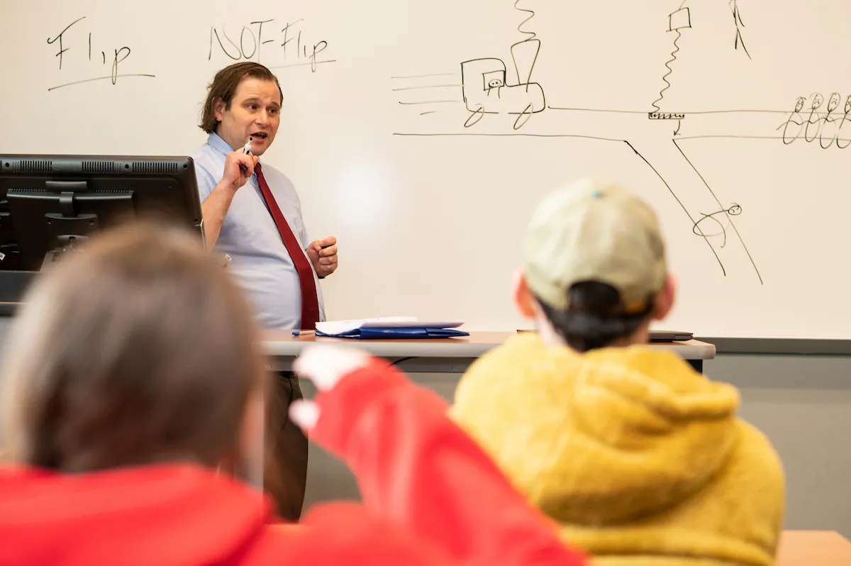 An A-State faculty member teaches on a whiteboard.