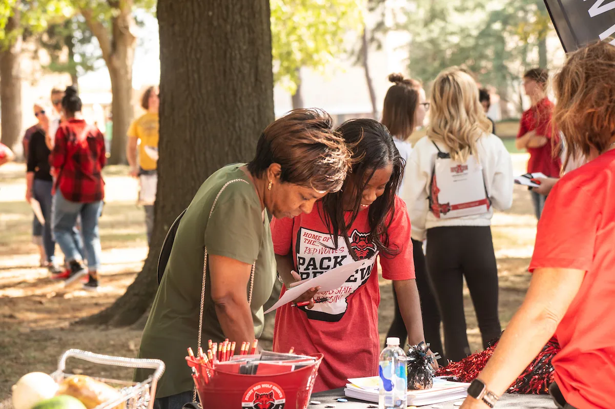 A mom and her daughter look at information during a Pack Preview event.