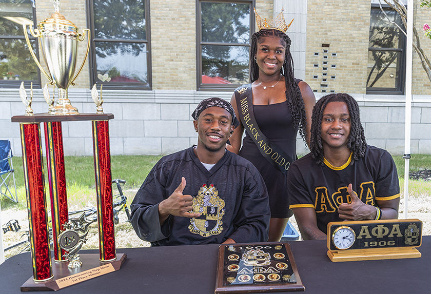 NPHC Fraternity men tabling with pageant queen at Community Fair.