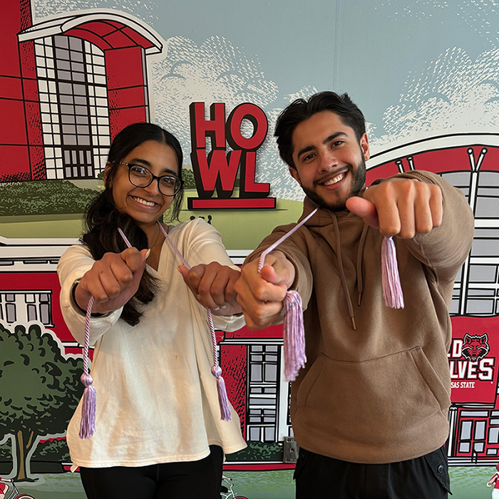 Students holding lavender graduation cords earned for service hours.