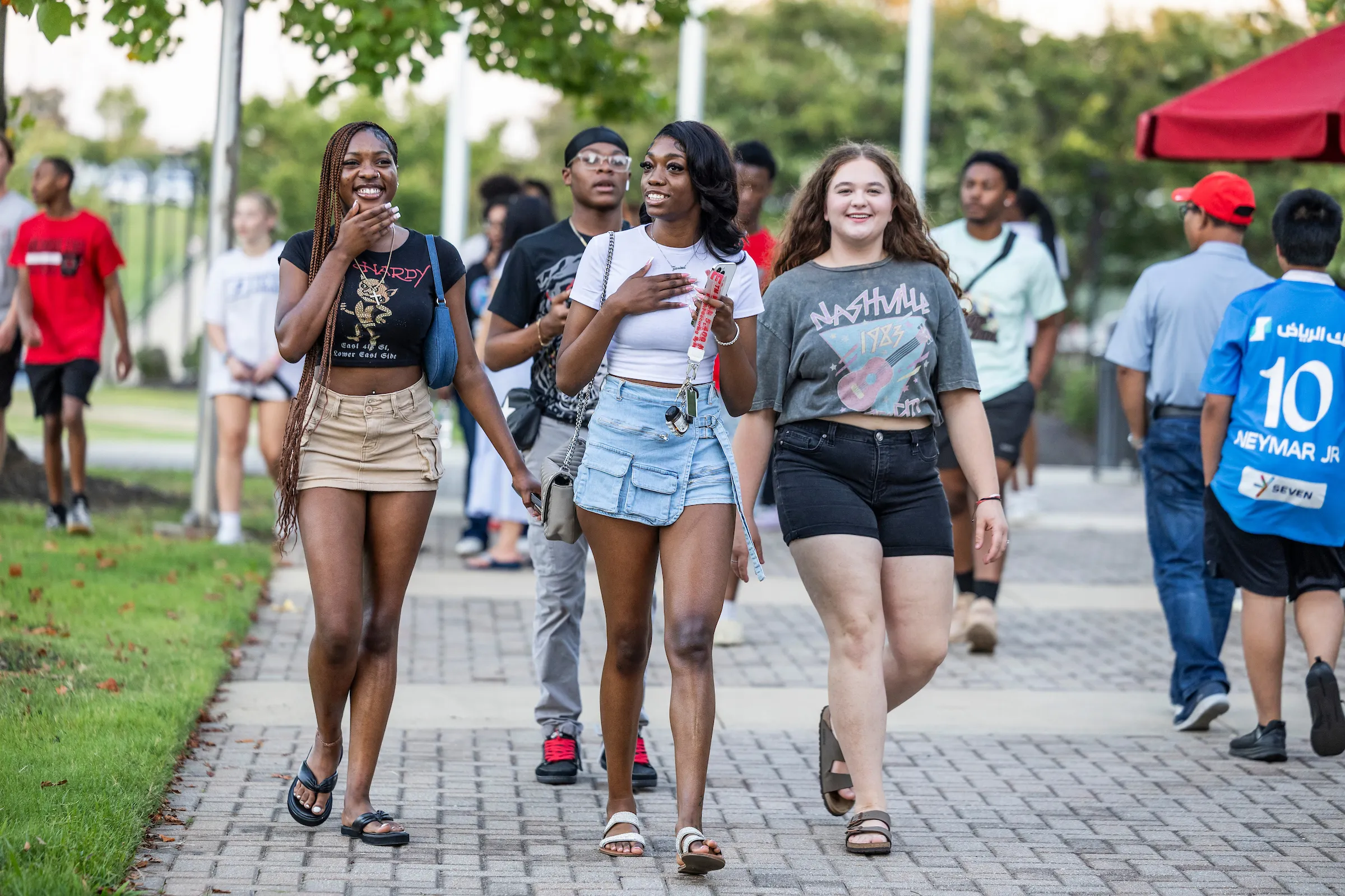 Group of students laugh and talk while walking together at a campus