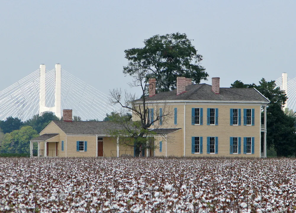 Lakeport Plantation house in a field of cotton, with parts of a modern bridge showing in the distance