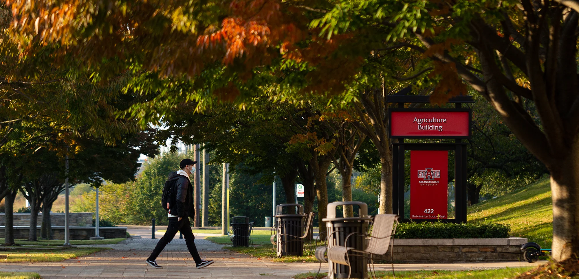 A student walking to the Agriculture building in autumn.