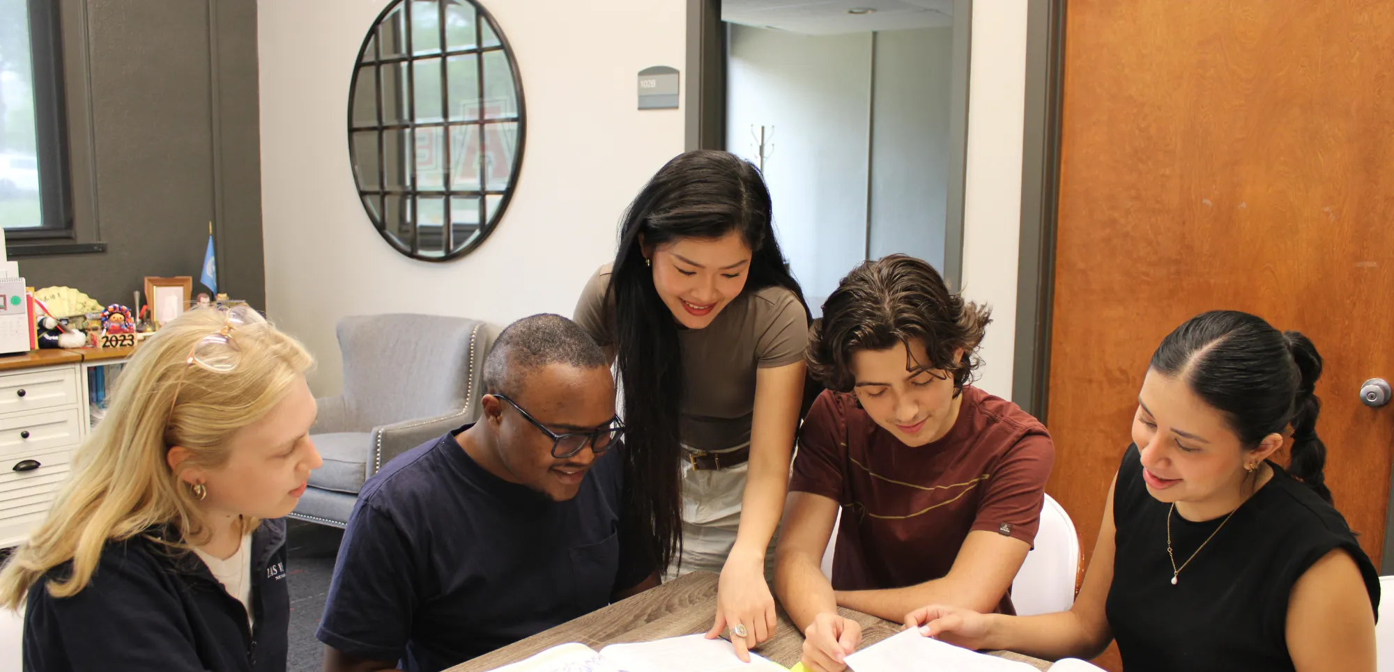 Neil Griffin college of business students working together over a book.