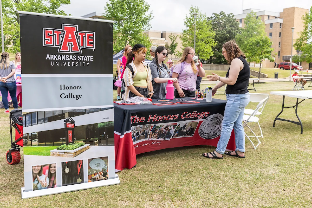 A student gets information at a booth for the Honors College at A-State