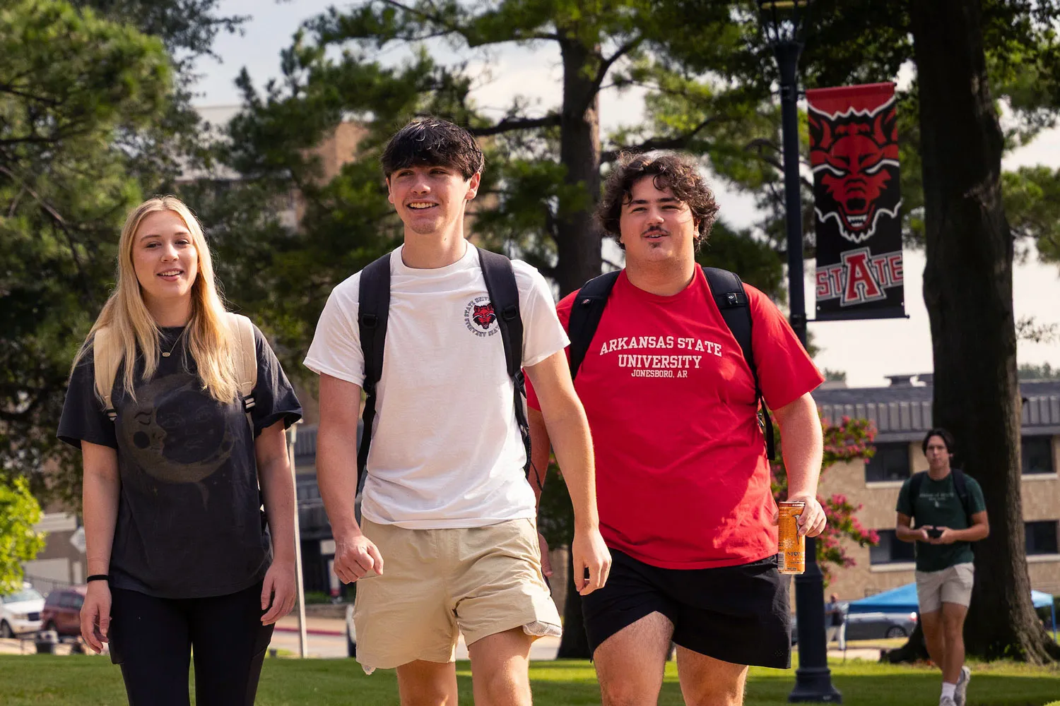students smiling and walking across campus
