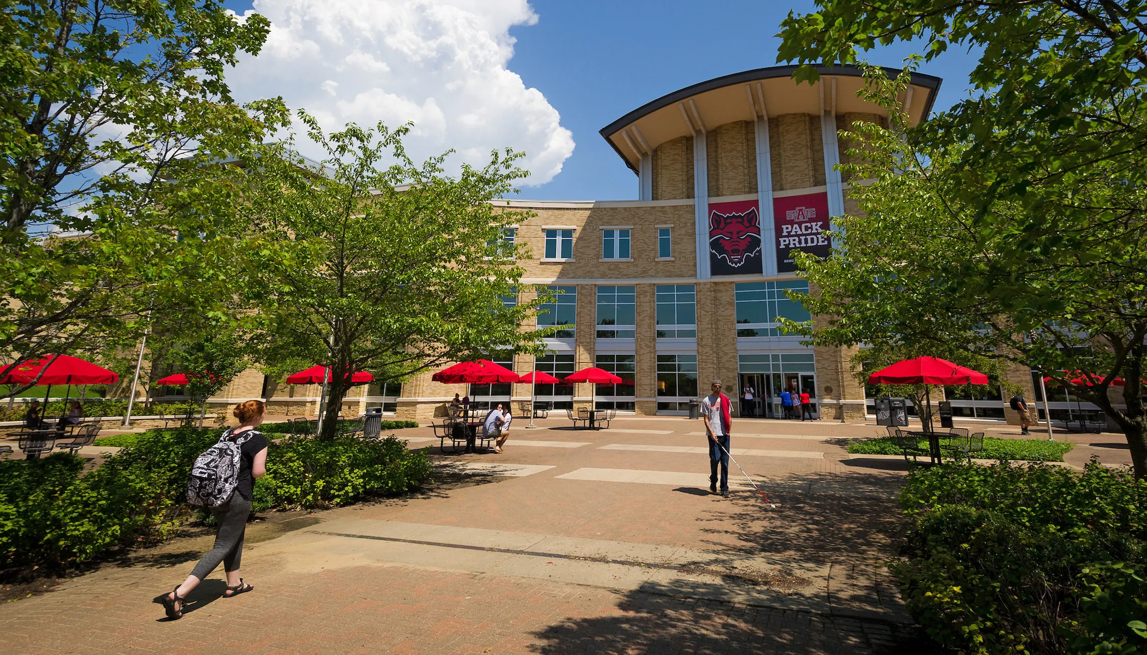 west side of Reng Student Union with blue sky and students walking by