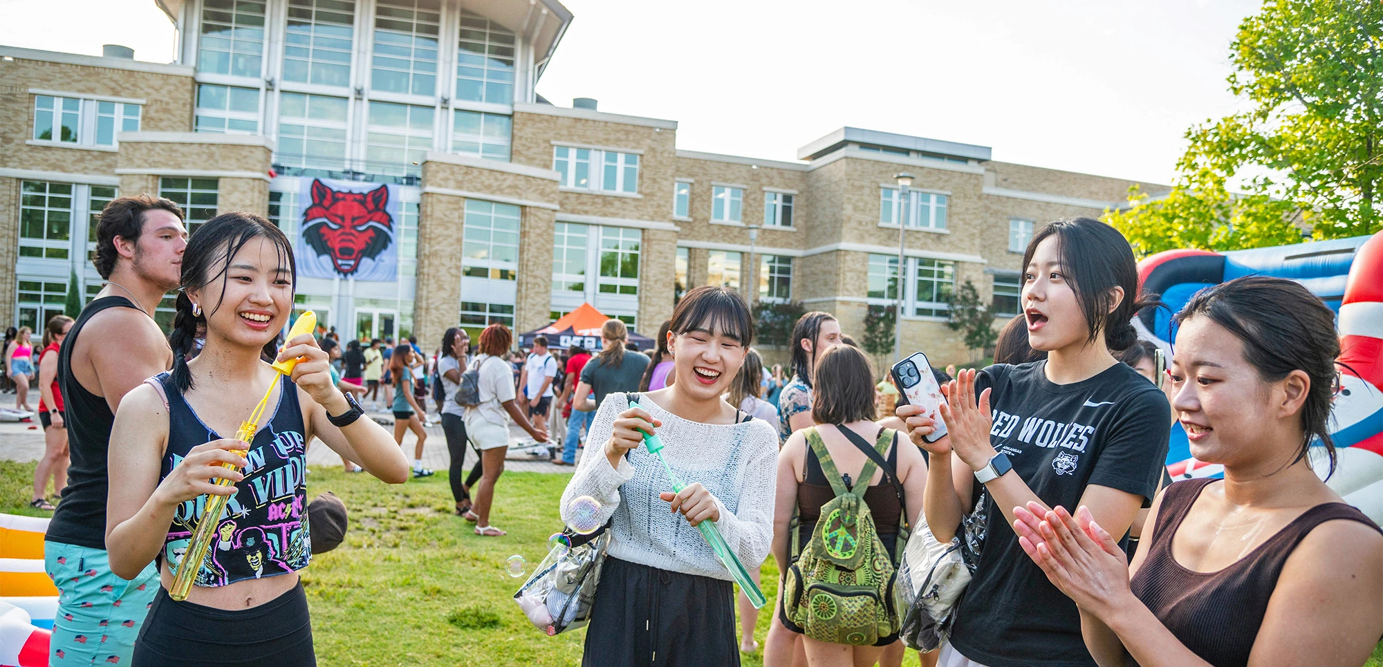 international students laughing and having fun on the Heritage Plaza Lawn at A-State