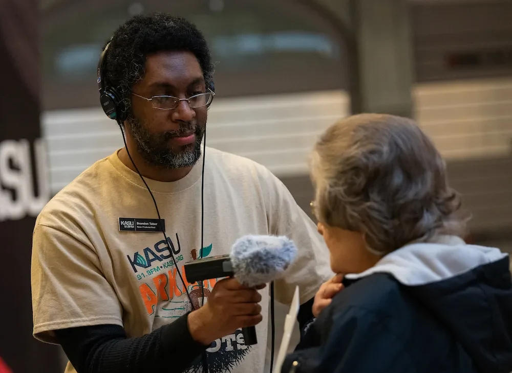 KASU Radio staff interviewing an event attendee.