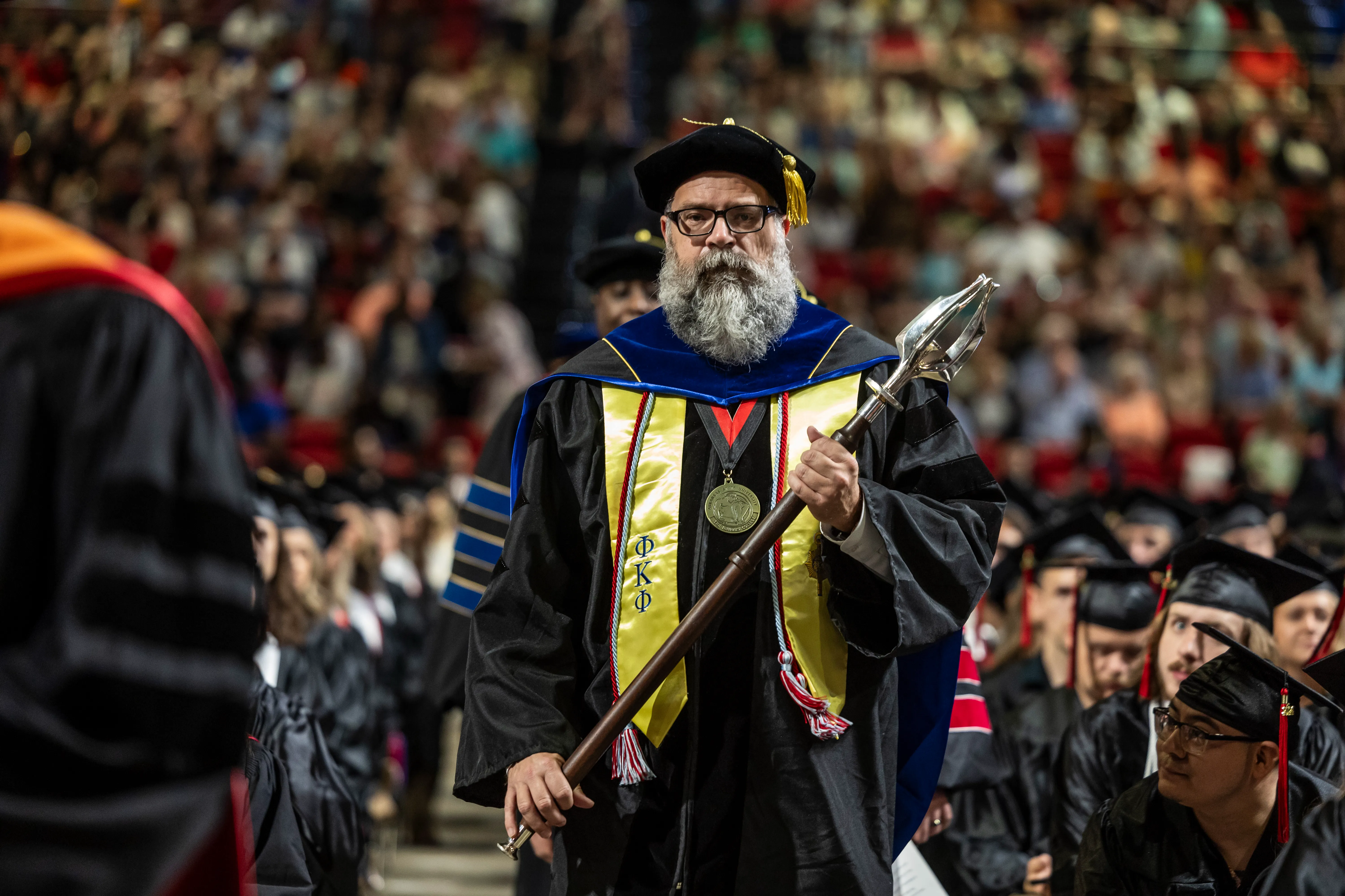 Dr. Ed Salo carries the mace throught he crowd at a recent graduation