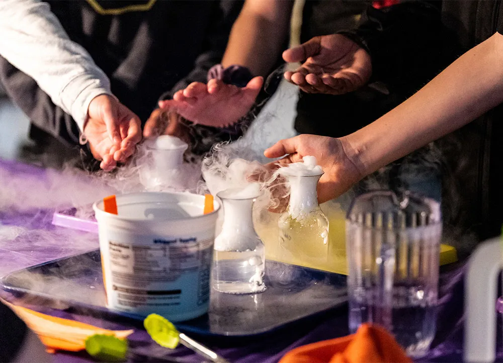 students experiment with beakers containing a smoking liquid