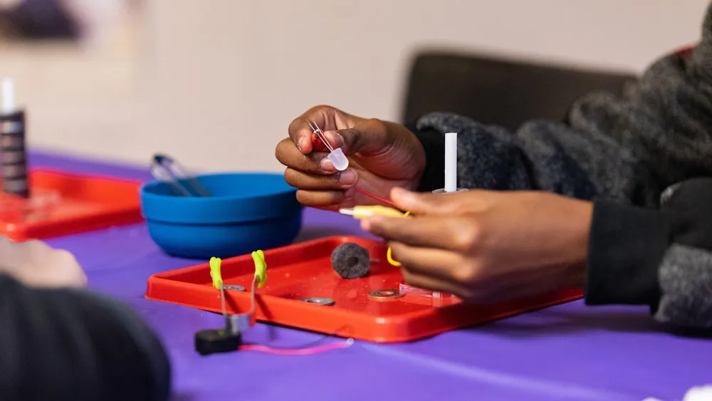 student experimenting with wires and lights